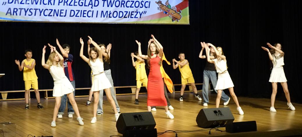 Na scenie w układzie tanecznym kilkunastoosobowa grupa uczniów SP w Domasznie